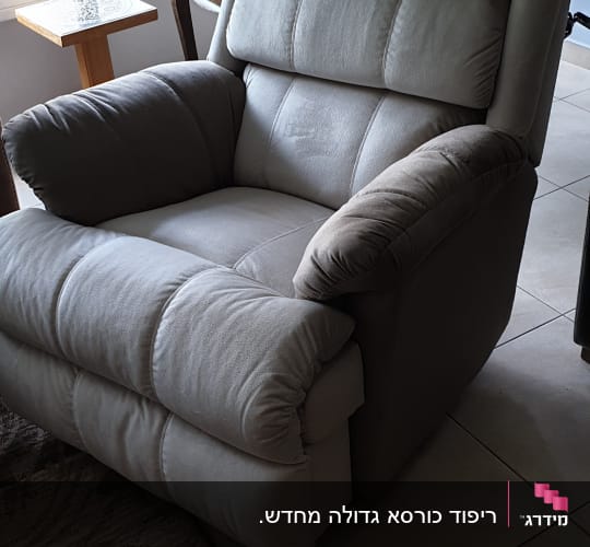 כורסה מרופדת בצבע אפור בהיר עם משענות מרופדות